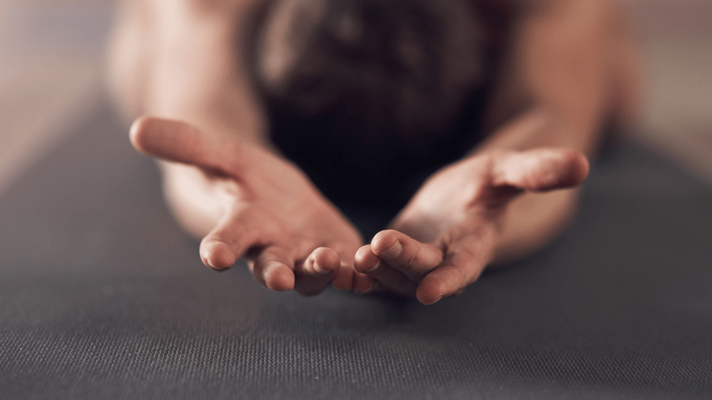 a person bowing on the floor with hands stretched before him